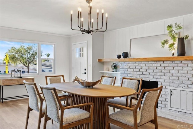 dining room featuring light hardwood / wood-style flooring, ornamental molding, and a notable chandelier