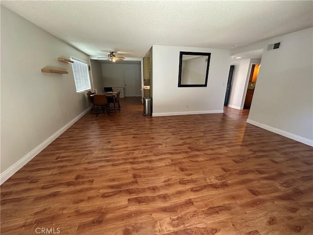 unfurnished room with dark hardwood / wood-style floors, ceiling fan, and a textured ceiling