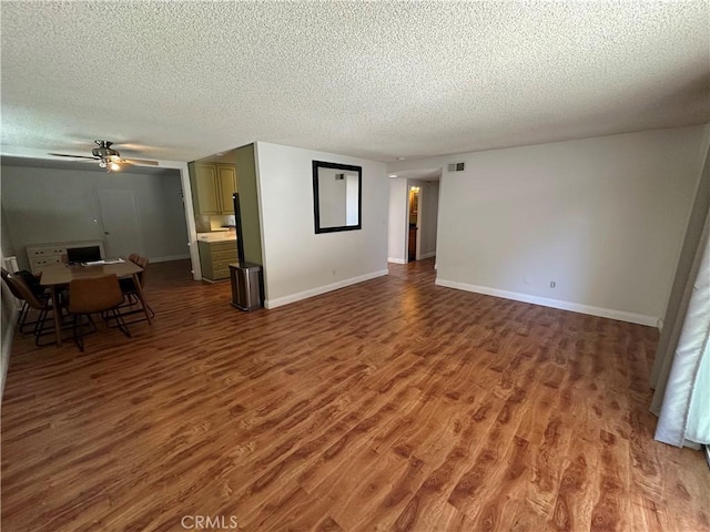 unfurnished living room with hardwood / wood-style floors, ceiling fan, and a textured ceiling