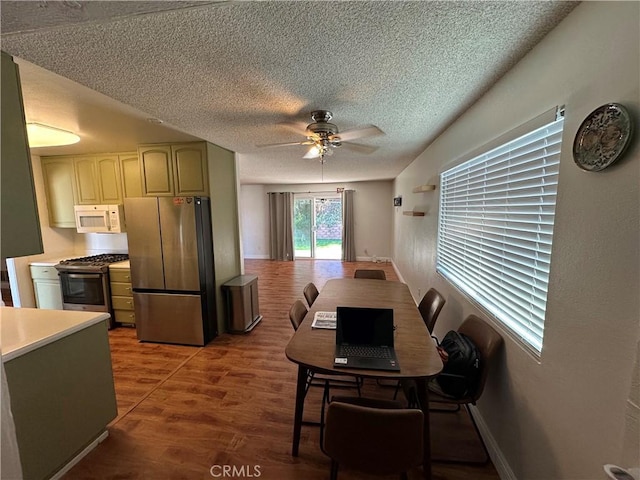 dining room featuring a textured ceiling, hardwood / wood-style flooring, and ceiling fan