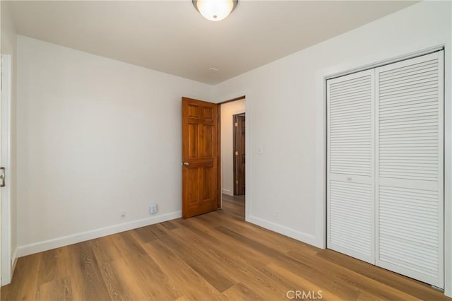 unfurnished bedroom with light hardwood / wood-style floors and a closet