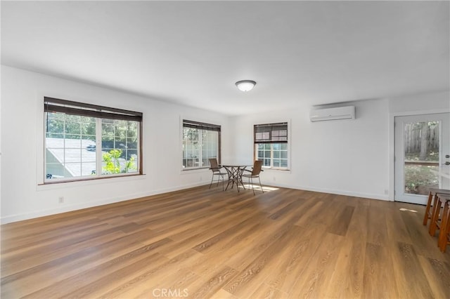 unfurnished room with hardwood / wood-style floors and a wall mounted air conditioner