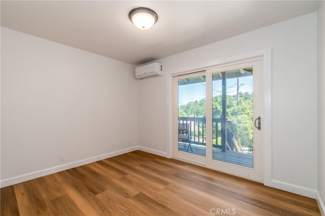 unfurnished room featuring light wood-type flooring and a wall unit AC