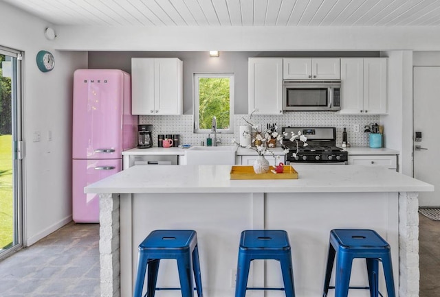 kitchen with a healthy amount of sunlight, white cabinets, and stainless steel appliances