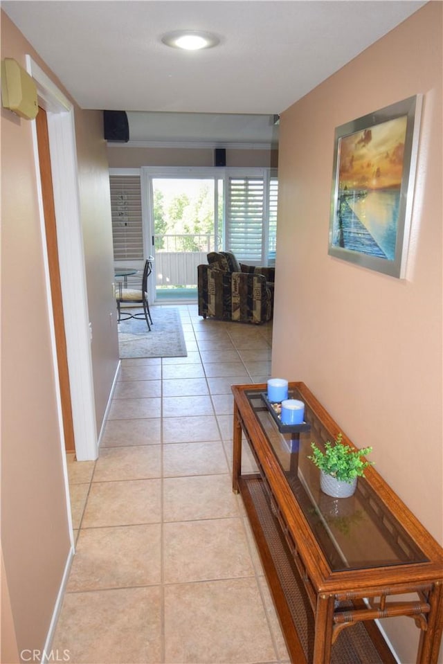 hallway featuring light tile patterned floors and baseboards