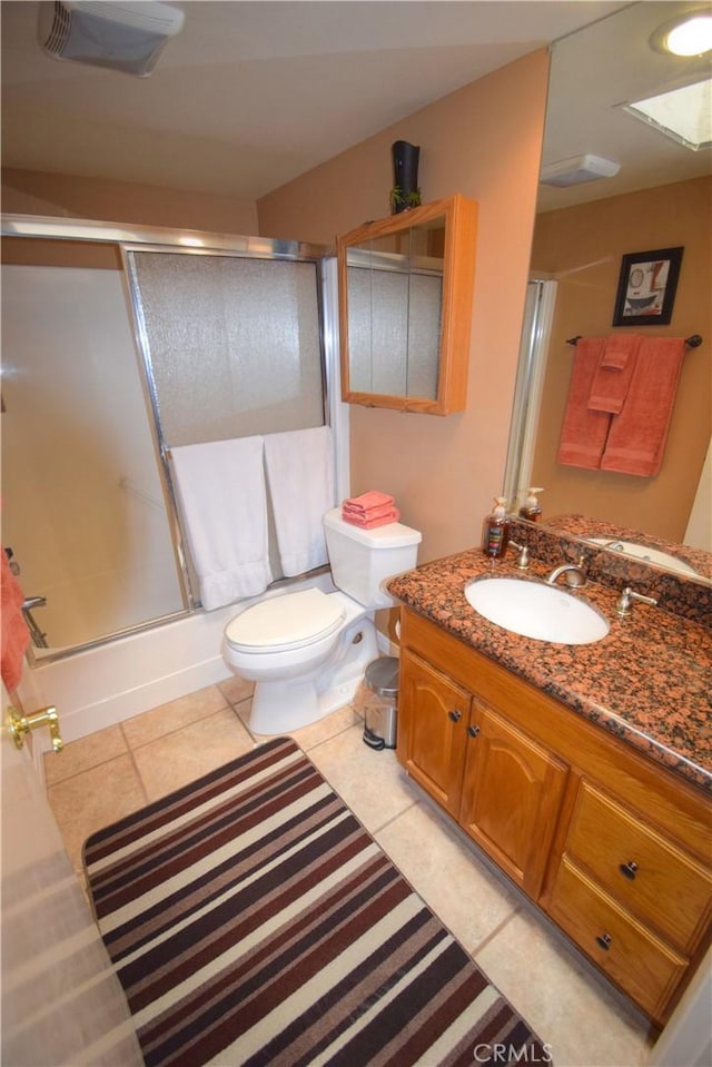 bathroom featuring shower / bath combination with glass door, toilet, vanity, and tile patterned flooring