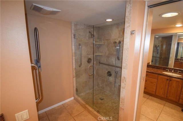 bathroom with tile patterned flooring, vanity, and a shower with shower door