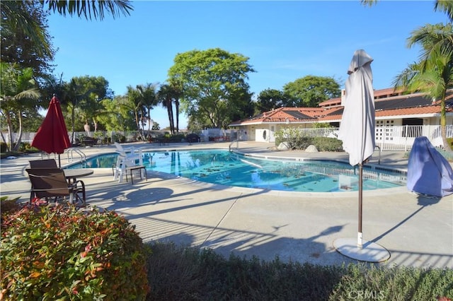 community pool featuring a patio and fence