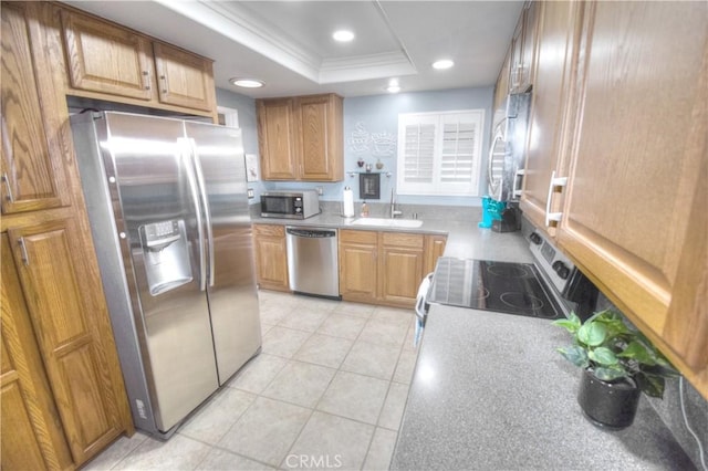 kitchen with sink, crown molding, light tile patterned floors, stainless steel appliances, and a tray ceiling