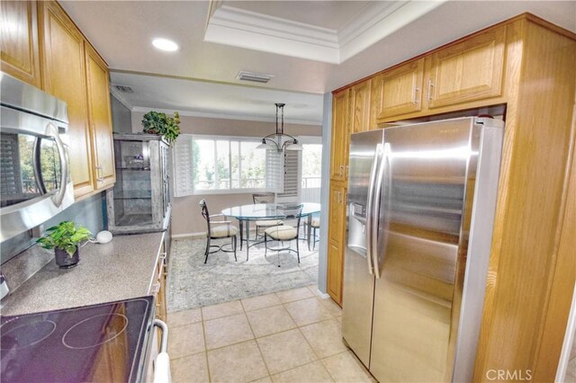 kitchen with light tile patterned flooring, ornamental molding, stainless steel appliances, and pendant lighting