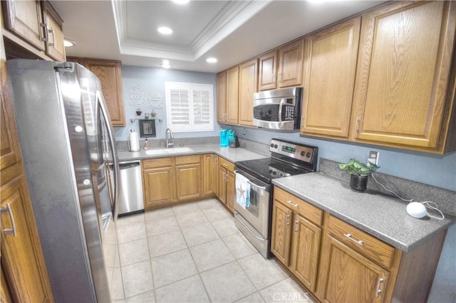 kitchen with sink, light tile patterned floors, stainless steel appliances, ornamental molding, and a raised ceiling