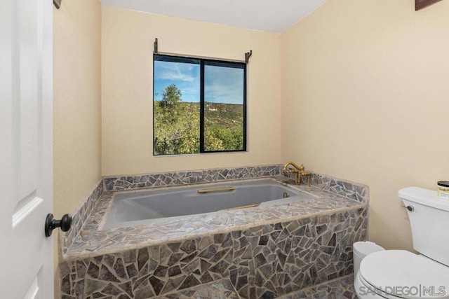 bathroom featuring tiled bath and toilet