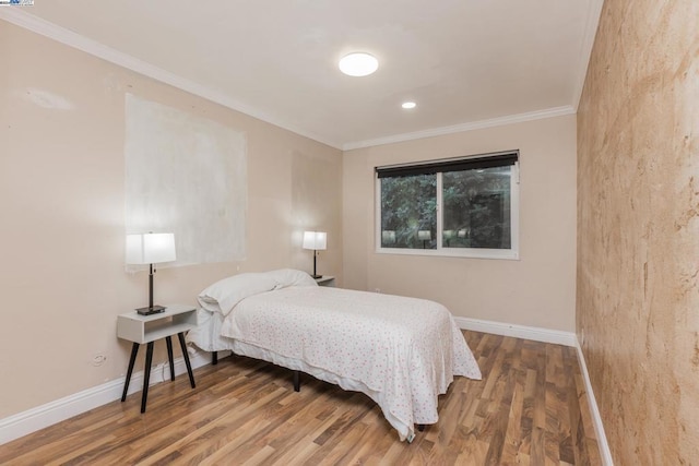 bedroom with hardwood / wood-style floors and crown molding