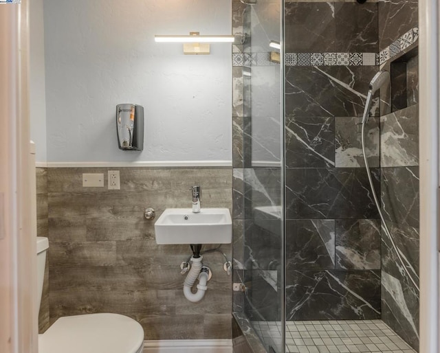 bathroom featuring sink, an enclosed shower, tile walls, and toilet