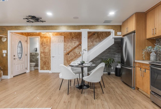 dining room with light hardwood / wood-style floors and crown molding