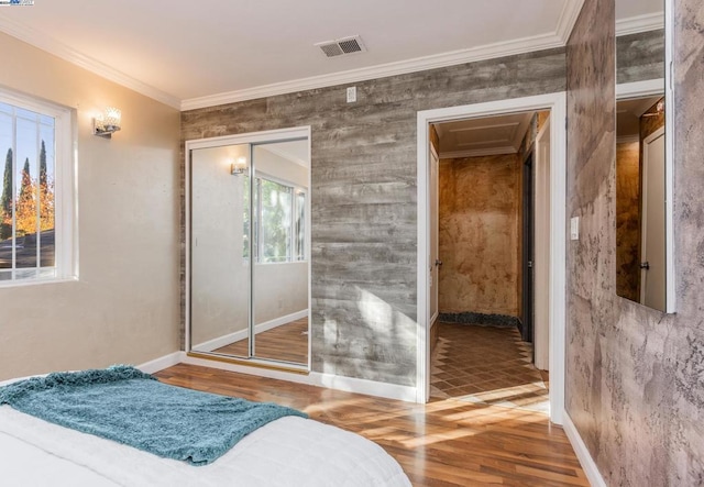 bedroom with crown molding, a closet, and hardwood / wood-style floors