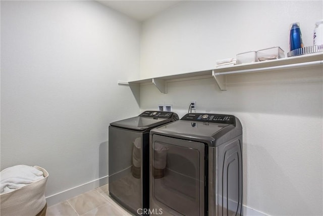 laundry area with separate washer and dryer and light tile patterned flooring