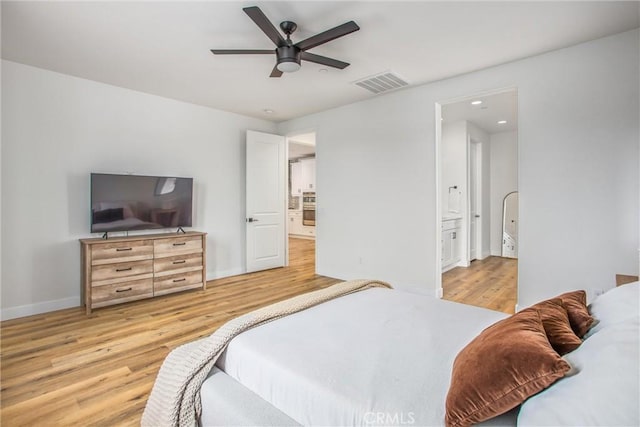 bedroom with ceiling fan, light wood-type flooring, and connected bathroom