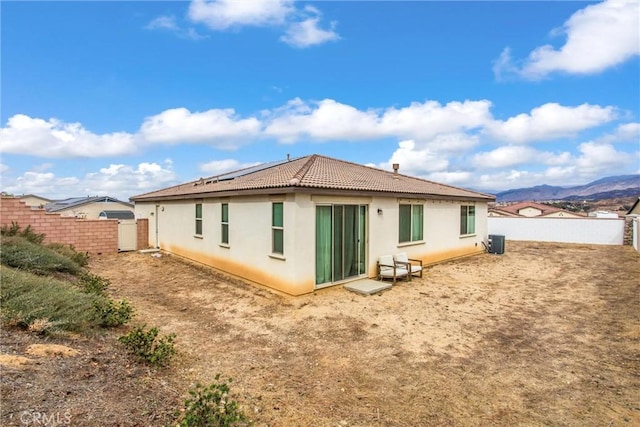 back of house with a mountain view and central air condition unit