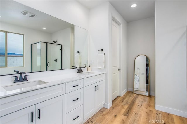 bathroom with hardwood / wood-style floors, vanity, and walk in shower