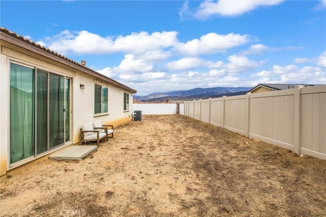 view of yard with central AC and a mountain view