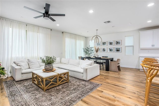 living room with light hardwood / wood-style flooring and ceiling fan