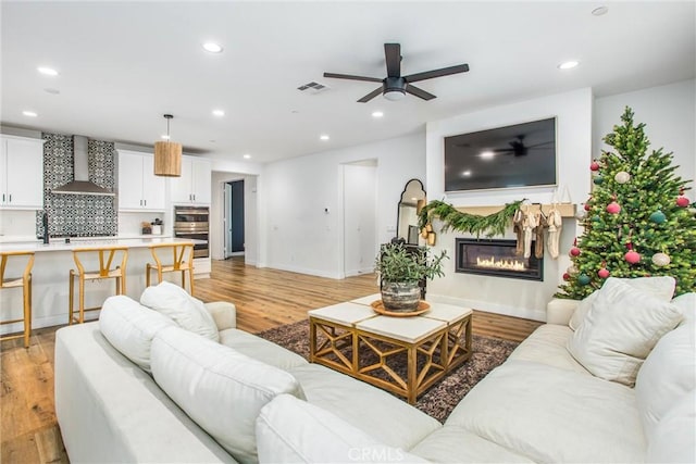 living room with light hardwood / wood-style flooring and ceiling fan