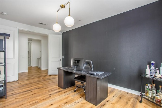 home office with light hardwood / wood-style floors