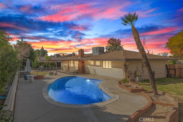 pool at dusk featuring cooling unit and a patio