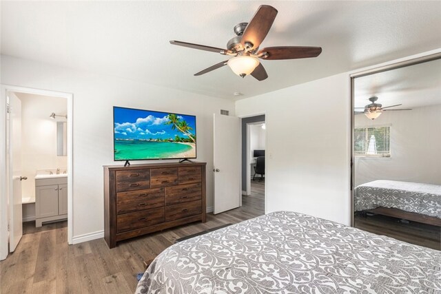 bedroom with ceiling fan, sink, connected bathroom, and hardwood / wood-style floors