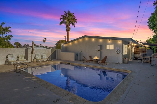 pool at dusk featuring a patio