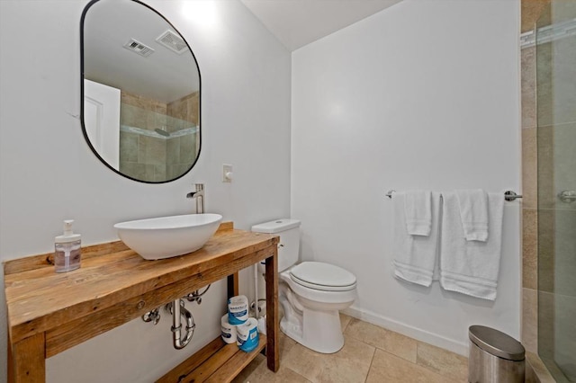 bathroom featuring tile patterned floors, sink, a shower with shower door, and toilet