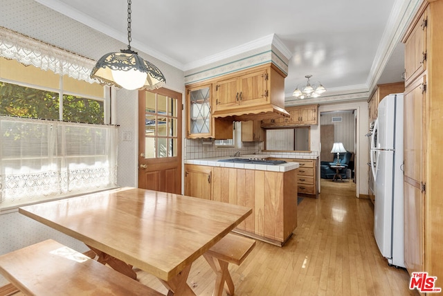 kitchen featuring kitchen peninsula, pendant lighting, white refrigerator, tile countertops, and light hardwood / wood-style flooring