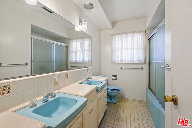 full bathroom with vanity, toilet, shower / bath combination with glass door, and backsplash