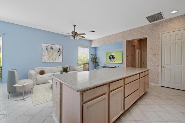 kitchen with ceiling fan, light brown cabinets, a kitchen island, and light tile patterned floors