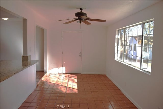 spare room featuring tile patterned floors and ceiling fan