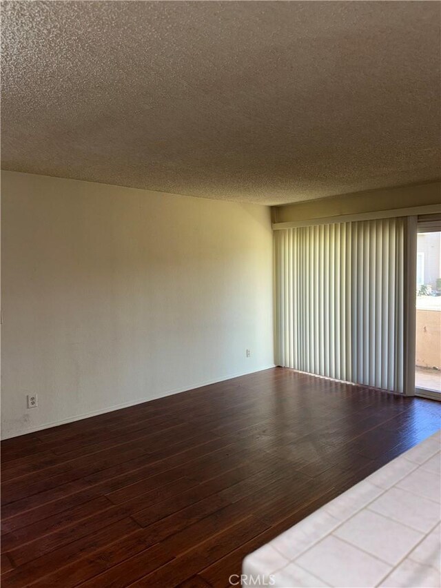 empty room featuring hardwood / wood-style flooring and a textured ceiling