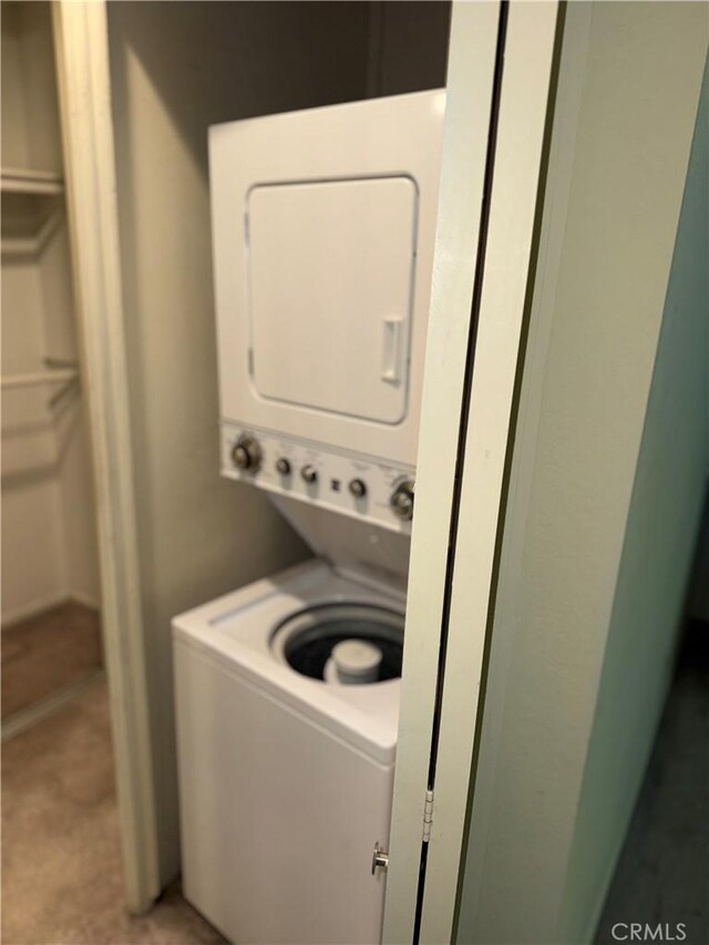 washroom featuring stacked washer / dryer