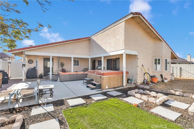 back of property featuring a yard, a patio area, outdoor lounge area, and a hot tub