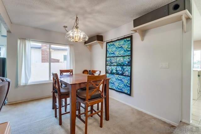 dining area with a textured ceiling, light colored carpet, and a healthy amount of sunlight