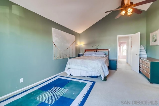 carpeted bedroom with ceiling fan and high vaulted ceiling