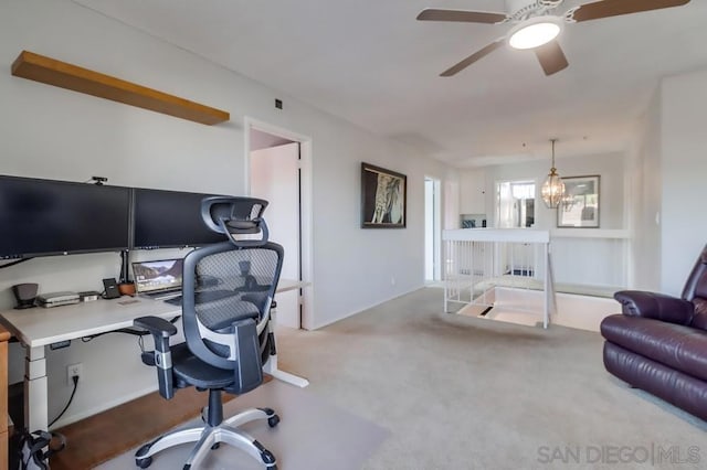 carpeted office space with ceiling fan with notable chandelier