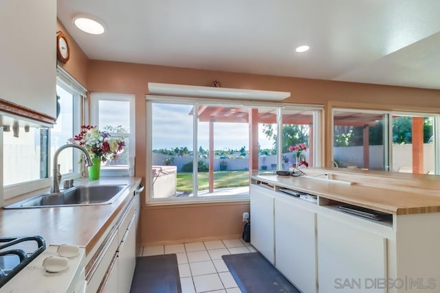 kitchen featuring plenty of natural light, white cabinets, and sink