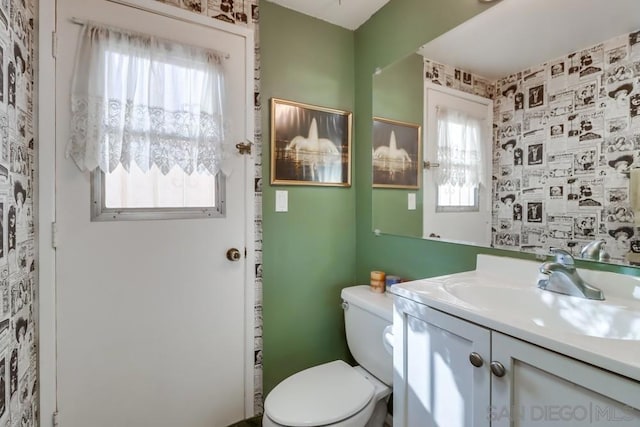 bathroom with plenty of natural light, vanity, and toilet