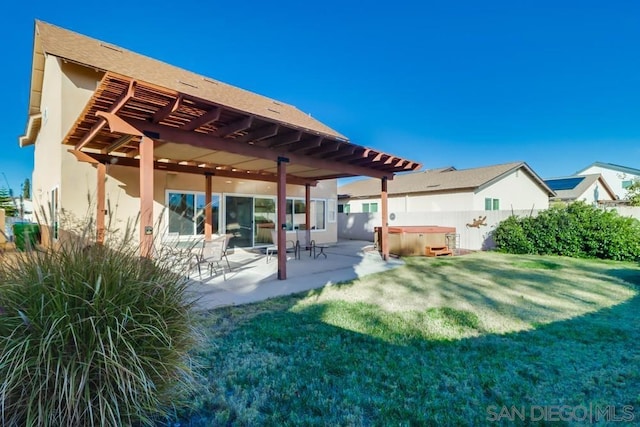 back of property with a lawn, a pergola, a patio, and a hot tub