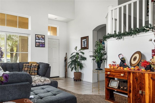 tiled living room with a towering ceiling