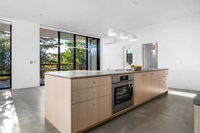 kitchen with pendant lighting, a center island, light brown cabinetry, and oven