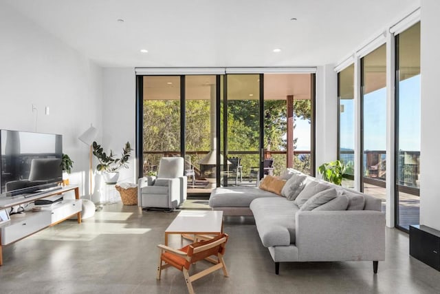 living room with a wall of windows and concrete flooring