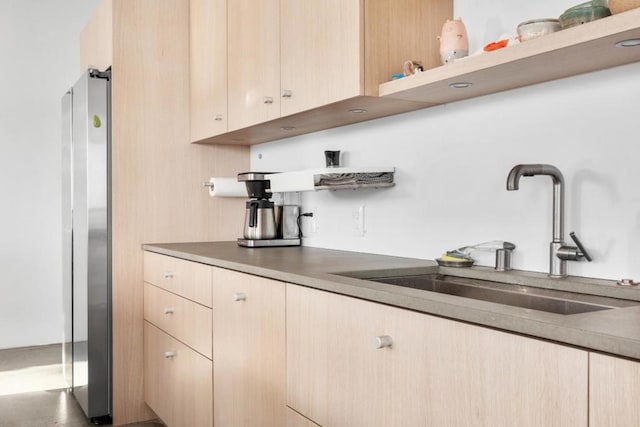 kitchen with stainless steel fridge, sink, and light brown cabinets