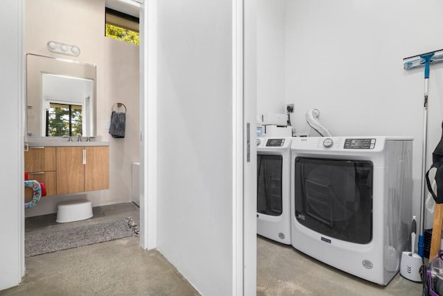 clothes washing area with a wealth of natural light and independent washer and dryer